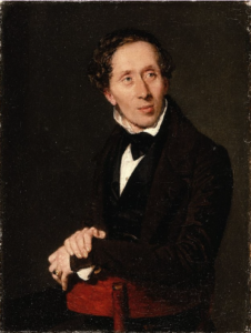 An oil painting portrait of Hans Christian Andersen in a black tuxe and bowtie leaning over the back of a red wooden stool. He is facing to the right. He has short slightly curly hair.