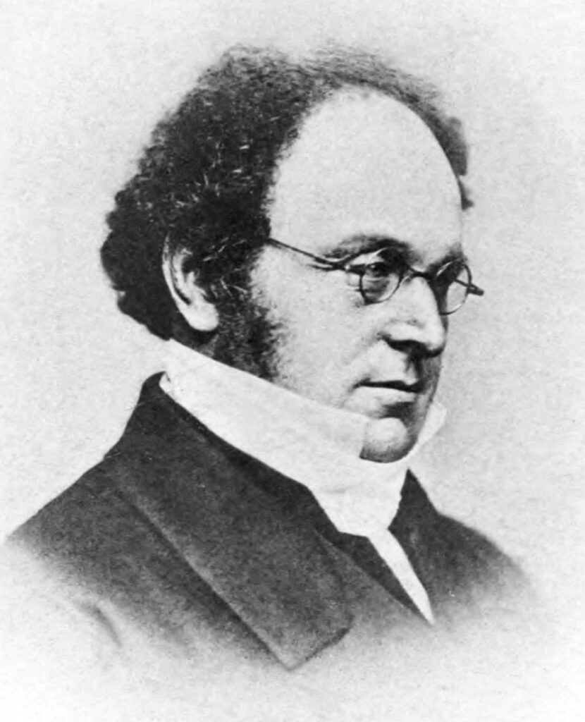 A portrait of Augustus de Morgan, a 19th century man with glasses and a high collar. 