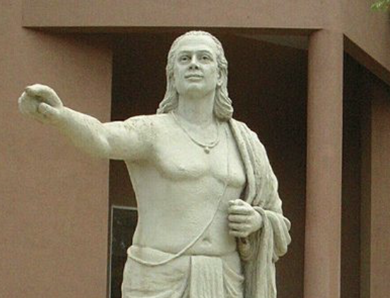 A staute of Aryabhata with one of his fingers pointing to the front.