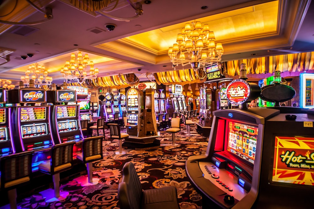 A brightly lit room filled with slot machines and chairs. 