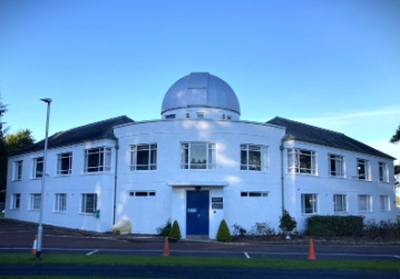 The observatory building that is the home of CREEM today. The building is white with the telescope dome at the center. 
